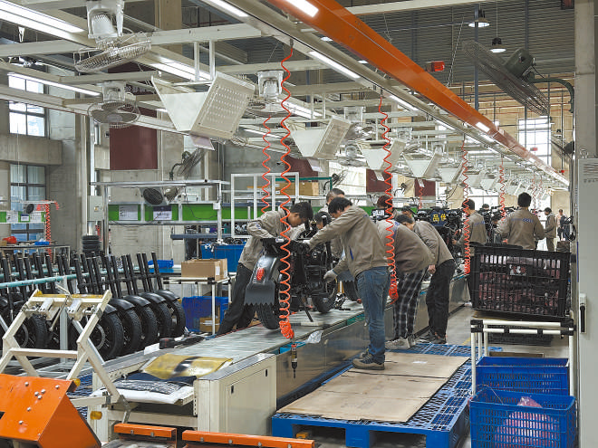 产业领跑 在长三角一体化发展格局下,新能源制造业通过产业集群协同发展,形成现代化产业体系。图为位于江苏常州市的比亚迪工厂内,工作人员正在组装销往非洲国家的电动摩托车。 拉丁美洲通讯社古巴籍摄影记者 朗尼·洛佩兹(中文名罗帅)摄